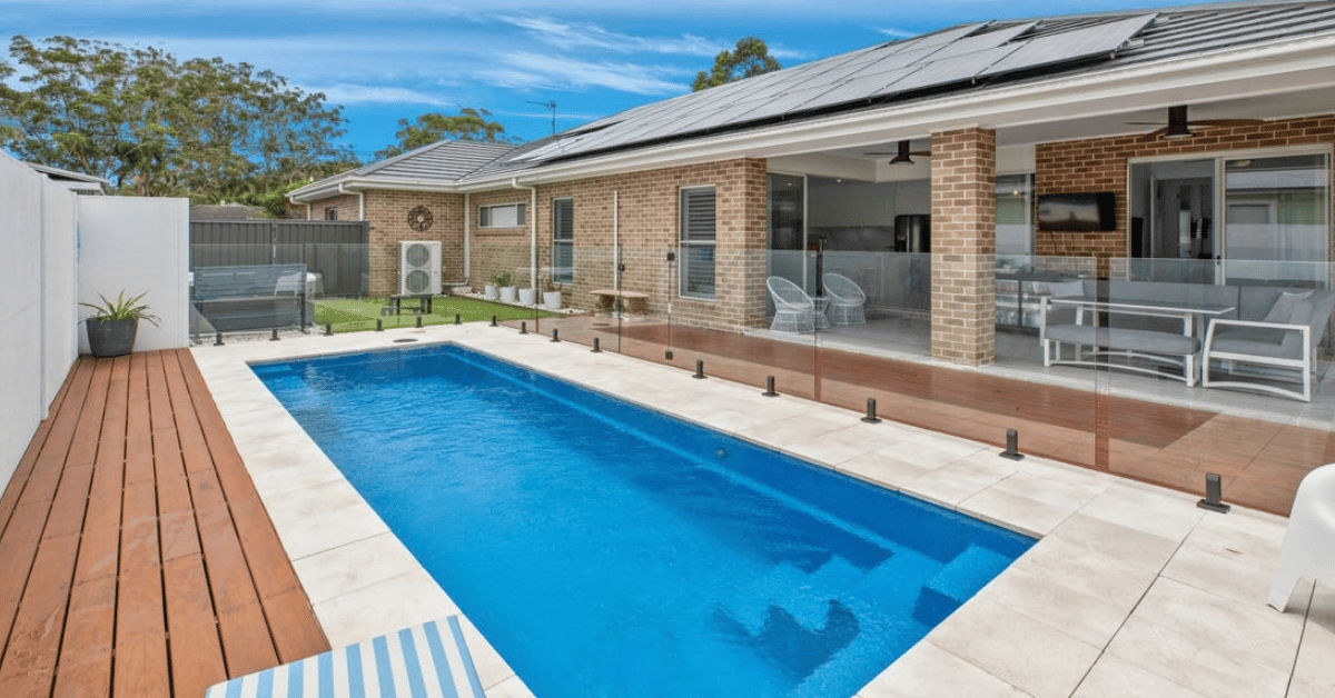 glass pool fence surrounding fibreglass pool in australian backyard 